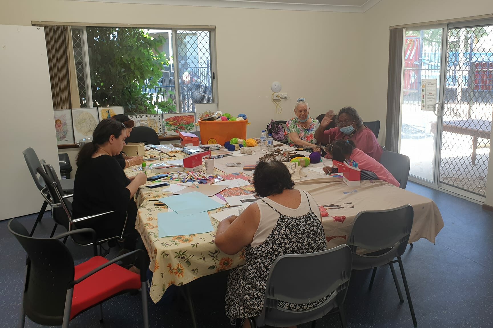 Women sitting around a table completing crafts 