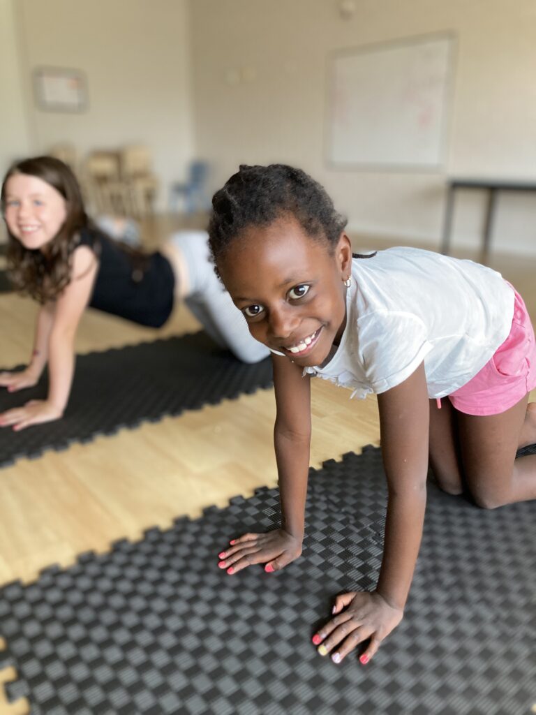 Wellbeing and yoga being completed by early learning children smiling