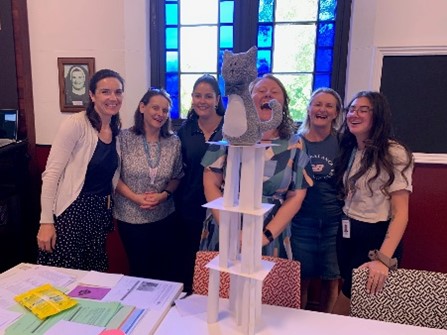 Staff gathered around structure during management course